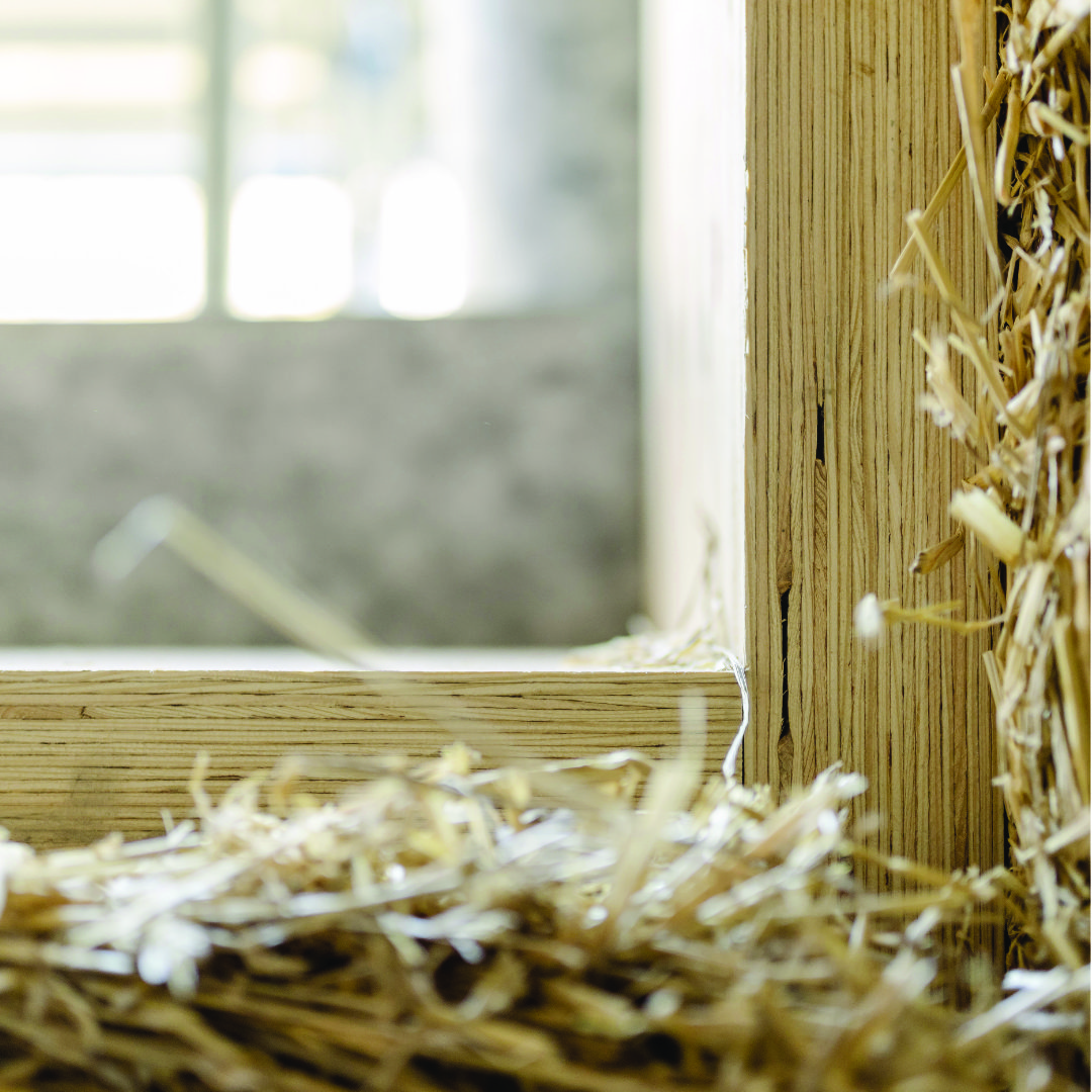 Patrick Schneider Detailansicht eines Holzrahmens mit Strohfüllung in nachhaltiger Bauweise.