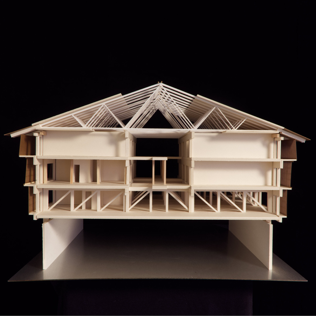 Architekturmodell eines modernen mehrstöckigen Gebäudes mit Holzstruktur auf schwarzem Hintergrund.