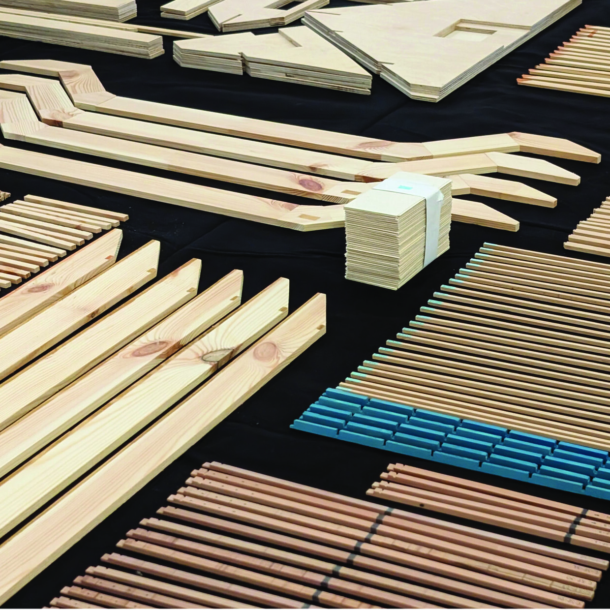 Benjamin Stöhrer Verschieden große und geformte Holzleisten und -platten für den Möbelbau auf schwarzem Hintergrund.